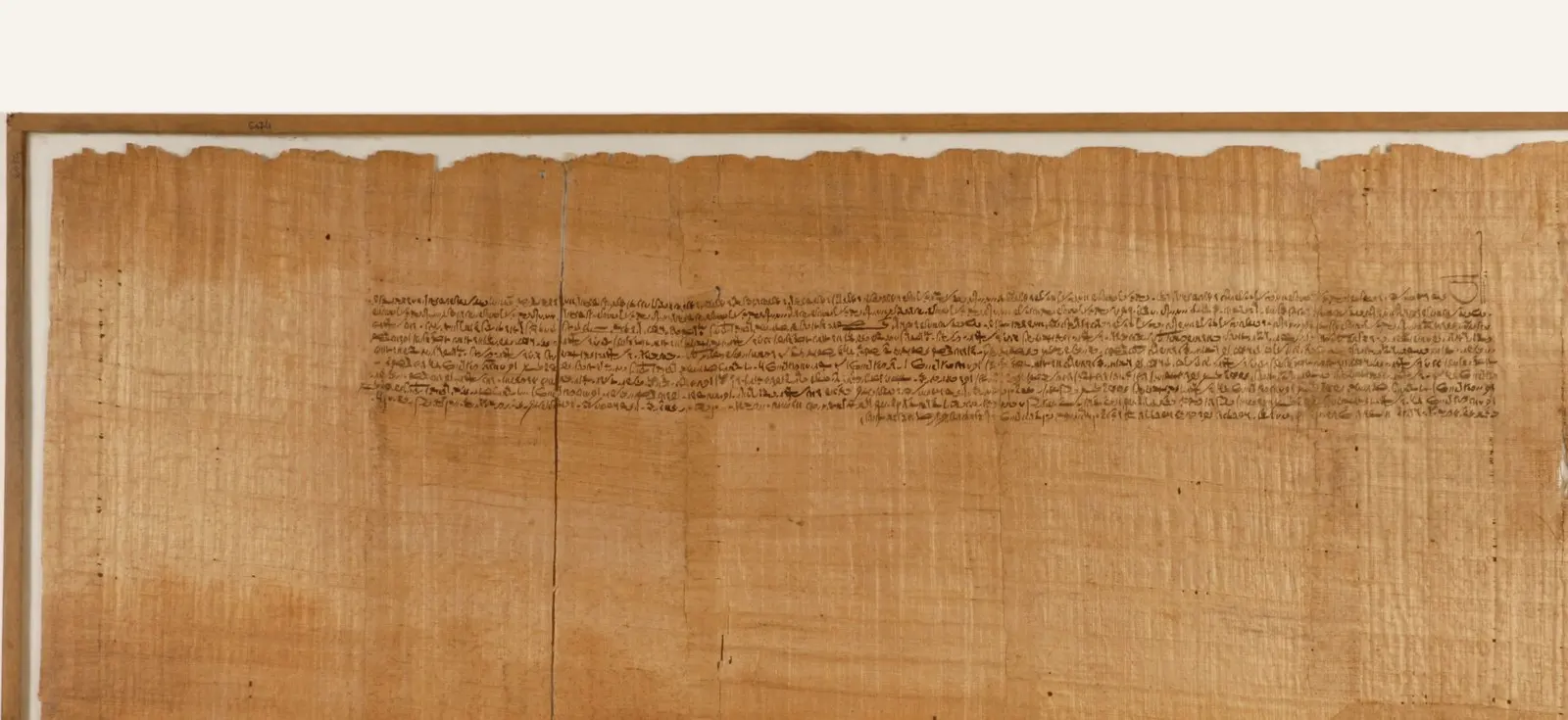 Demotic papyrus, 145 to 116 BCE, in a wooden frame, with a band of tiny script across its upper half