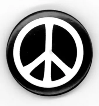 Photo: a round black CND button badge with the white peace symbol, photographed in 2010